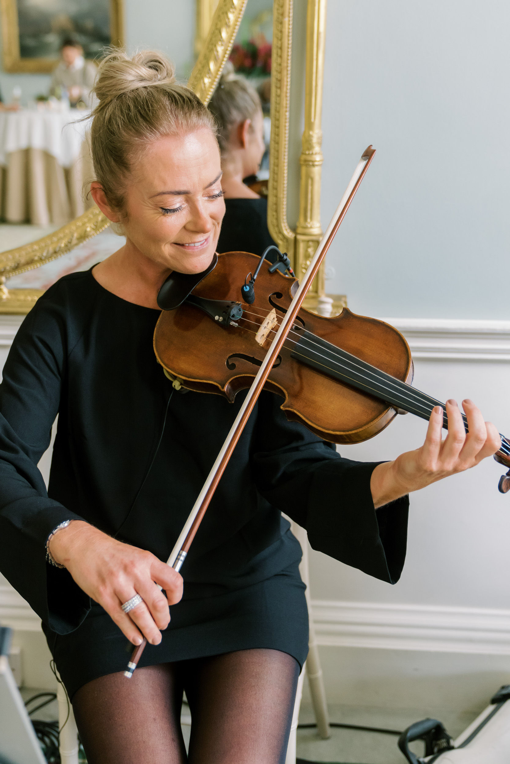 Female violinist performing live music at a high tea event.